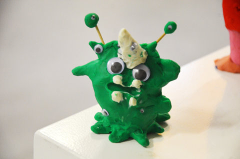 Knetfigur: ein grünes Wesen mit vielen Augen und Antennen