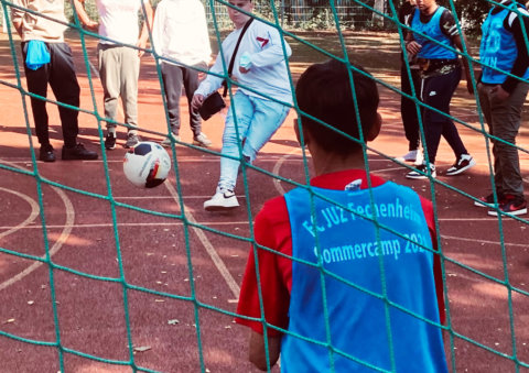 Sportplatz: Kinder spielen Fussball